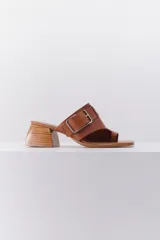Sandalias de cuero color marrón claro, con punta abierta y tira ancha sobre el empeine con hebilla metálica. Taco geométrico de madera.
