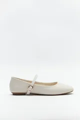 Balerinas color crudo de símil cuero texturizado, con punta redondeada, tira sobre el empeine y hebilla metálica ajustable.