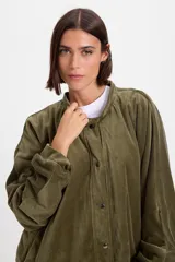 Campera de terciopelo color chocolate, con corte holgado, mangas murciélago y capucha desmontable. Presenta cierre frontal con botones a presión y bolsillos laterales.