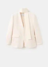 Blazer Martin de diseño recto y color beige, con cuello en pico, sin solapa, manga larga y bolsillos frontales de parche. Incluye forro interior.