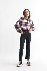 Buzo crop de corderito con estampado a cuadros en blanco, negro y rojo, con cierre de cremallera en el cuello.