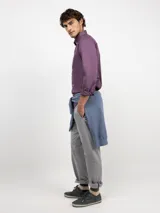 Camisa de hombre color azul, con cuello buttondown, cierre frontal con botones y logo bordado en el pecho. Presenta un acabado vintage logrado mediante el proceso de teñido en prenda.