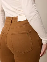 Jean de corte recto y tiro alto, confeccionado en denim azul oscuro con costuras en contraste. Presenta diseño clásico de cinco bolsillos, cierre frontal con botón y bragueta.