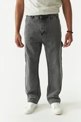 Jean estilo carpenter de corte relajado, recto y amplio, con diseño de cinco bolsillos y costuras reforzadas características del modelo. Presenta un acabado lavado en tono gris oscuro.
