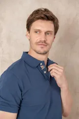 Chomba azul de piqué de algodón con cuello polo, tapeta de dos botones con diseño estampado en el interior y mangas cortas. Corte clásico.