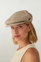 Boina con visera y orejeras de lana color beige con diseño de espiga.