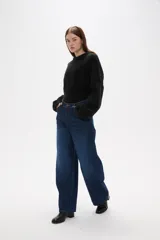 Pantalon jean de corte barrel y tiro medio, en color negro, con diseño de pierna ancha y estructura rígida.