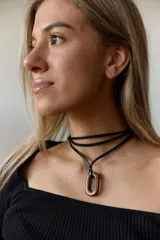 Collar con tiento negro y dije de piedra natural ovalada en tonos grises y azules.