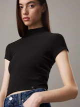 Remera negra de punto de viscosa elástica con textura de canalé irregular, corte slim, cuello perkins y mangas raglán cortas.
