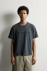 Camiseta relaxed fit de manga corta y cuello redondo, color gris oscuro, con estampado en relieve tono sobre tono con la palabra 'MODULE' en el frente.