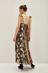 Vestido largo con escote en V profundo y tirantes con volados. Presenta un diseño patchwork con diferentes estampados florales y texturas en tonos tierra, negro y dorado metalizado.