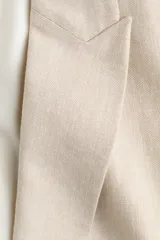 Blazer de botonadura sencilla en mezcla de lino, color beige, con solapas de pico, hombreras y un botón frontal.