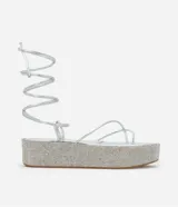 Sandalias plateadas con plataforma flatform cubierta de strass, tiras finas y lazo para atar al tobillo.