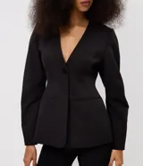Blazer sastre Blue Steel de color negro, confeccionado en poliéster con elastano y forro de poliéster. Presenta un diseño estructurado con escote en V pronunciado, cierre frontal de un botón y bolsillos con solapa en los laterales. Las mangas largas tienen volumen tipo cocoon.