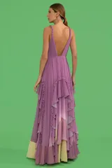Vestido largo lila con degradé amarillo, de tirantes finos retorcidos, busto plisado, escote cruzado, espalda descubierta y falda con volados.