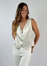 Chaleco blanco con escote en V y abotonadura frontal.