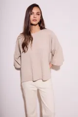 Sweater color beige de tejido de punto, con cuello redondo y mangas 3/4 con volados.