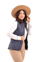 Chaleco capitoneado color rosa claro, con cuello alto, cierre frontal con botones a presión y logo bordado en el pecho.