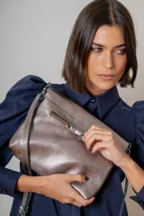 Sobre de cuero color suela con solapa frontal decorada con una piedra de ágata natural enmarcada en metal. Incluye correa larga ajustable y extraíble para usar como bandolera.