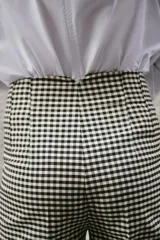 Pantalón tobillero de tiro alto con estampado de cuadro vichy, costuras marcadas en delantero y espalda, bolsillos delanteros de vivo y cierre frontal con cremallera, botón interior y gancho metálico.