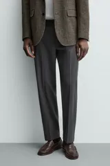 Pantalón de vestir regular fit color negro, confeccionado en tejido con mezcla de lana y elasticidad. Cuenta con cintura elástica, bolsillos frontales, bolsillos traseros de vivo con botón, y cierre frontal con cremallera y botón.