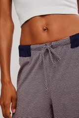 Pantalón de descanso de tiro alto y pierna ancha con estampado de micro-rayas. Cuenta con cintura elastizada, cordón de ajuste y detalle acanalado en la parte superior.