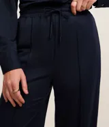 Pantalón recto de tiro alto color azul marino, confeccionado en piqué, con cintura elástica, cordón ajustable y costura central en la parte delantera.