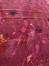 Mantel rectangular de lino color rosa con estampado de hojas y flores en tonos naranja, marrón y blanco.