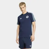 Remera Adidas de la selección de Alemania, línea Originals, color azul marino. Presenta cuello redondo, mangas cortas con las tres tiras características en celeste, logo del Trifolio en el pecho derecho y escudo de la federación alemana en el pecho izquierdo.