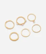 Kit de seis anillos dorados de diseño fino y delicado, con texturas variadas, relieves y aplicaciones de pequeñas perlas sintéticas.