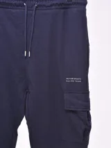 Pantalón de jogging negro con bolsillos cargo laterales, cintura elástica ajustable con cordón y puños elásticos.