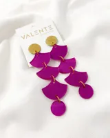Aros colgantes con piezas circulares doradas y piezas semicirculares fucsias.