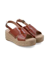 Sandalia de plataforma con yute trenzado, tiras cruzadas de cuero marrón arrugado y tira ajustable al talón con hebilla metálica.