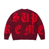 Sweater de punto Supreme en color bordó, con diseño de punto cruzado y grandes letras rojas formando la marca en la parte frontal y las mangas. Cuenta con cuello redondo y ajuste regular.