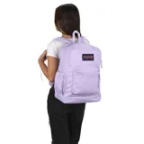 Mochila JanSport color lila con logo de la marca en el frente. Tiene un compartimento principal, un bolsillo frontal con cierre, un bolsillo lateral para botella de agua y un sobre interno acolchado para laptop de 15 pulgadas.