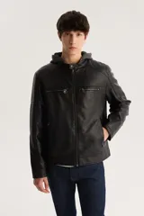 Campera de cuero sintético negra con capucha de algodón gris, cierre frontal con cremallera, bolsillos laterales con cremallera y detalles acolchados en hombros y mangas.