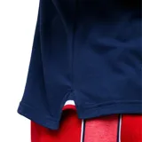 Remera polo azul marino con cuello clásico y puños con detalles tricolor (blanco, rojo y azul). Presenta logo de la marca Umbro bordado en blanco y escudo del Club Nacional de Football bordado en el pecho. Fabricada en tejido suave y respirable.