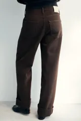 Jeans de tiro medio con corte baggy y pierna relajada. Presenta diseño de cinco bolsillos, cierre frontal con cremallera y botón, y bajo acabado con vuelta.