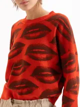 Sweater tejido semi pesado color rojo con estampado de labios en marrón, de corte holgado, escote redondo y mangas largas con hombros caídos.