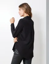Camisa de satén color violeta, con cuello clásico, cierre frontal con botones, manga larga con puños anchos abotonados y bolsillo aplicado en el pecho.