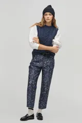 Pantalón sastrero de tiro alto con estampado de leopardo en tonos azulados, corte carrot, cintura ceñida con pliegues frontales, bolsillos laterales y bolsillo de ojal trasero.