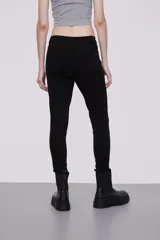 Pantalon skinny de tiro medio, confeccionado en tejido de algodón con elastano, con cierre frontal y bolsillos laterales.