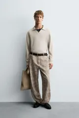 Pantalón de corte relajado confeccionado en tejido ligero de algodón con estampado abstracto de efecto lavado. Presenta cintura elástica, bolsillos frontales y bolsillos traseros de plastrón, con cierre frontal de cremallera y botón.