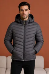 Campera puffer con capucha, diseño acolchado con costuras horizontales, cierre frontal completo y bolsillos laterales con cierre.