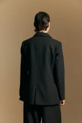 Blazer de corte sastrero con solapas clásicas y estructura definida. Presenta un diseño versátil con silueta ligeramente oversized, ideal para un estilo sofisticado y atemporal.