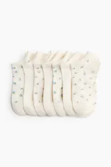 Pack de siete soquetes de color blanco con delicados estampados florales dispersos en tonos rosados y azules.