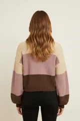 Sweater de tejido grueso, holgado, con cuello redondo y diseño de bloques de color horizontales en verde salvia, beige y marrón caramelo.