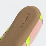 Championes Adidas modelo Tokyo de estilo retro, con exterior de nylon en color rosado y detalles en amarillo neón en las tres tiras laterales y el talón. Presenta una suela de caucho en tono marrón y un diseño de corte bajo.