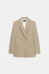Blazer cruzado de color tostado con cuello de solapa, manga larga y bolsillos frontales con solapa. Cierre frontal con botones.