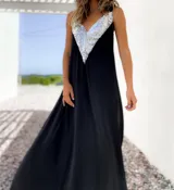 Vestido largo de fiesta color negro, con escote en V profundo decorado con lentejuelas plateadas y breteles anchos.